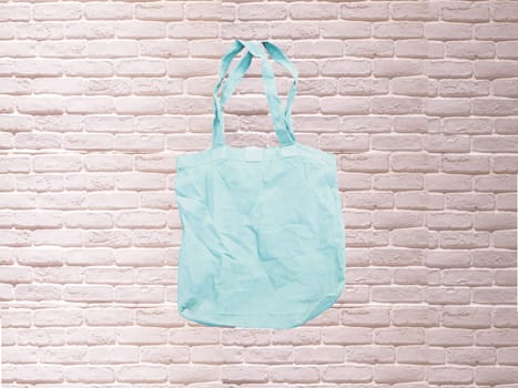Mock up Tote bag eco hipster white cotton fabric Shopping bag in blue . white brick eall rustic background