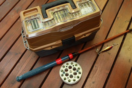 fishing tackle, rod with a reel and a bait,  fishing box for fishing still life