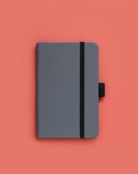 Grey hardcover notebook on red top view. Textbook cover mockup, planner cover with place fot text. Educational, business and organizing concept