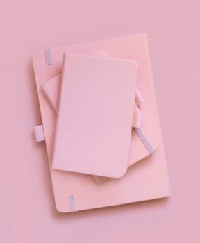 Stack of pink notebooks on light pink top view. Textbook mockup, planner cover with place fot text. Educational, business and organizing concept