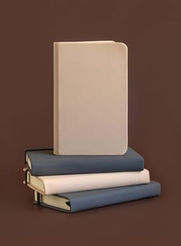 Stack of beige and grey hardcover notebooks isolated on brown closeup. Textbook mockup, planner cover with place fot text. Educational, business and organizing concept