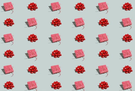Gray green background pattern with Christmas, New Year symbol attribute objects and symbolic items concept. Pink little gift box present with ribbon, small red tied bow. Book cover, covering paper