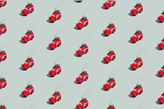 Gray green background pattern with Christmas or New Year symbol attribute objects and symbolic items concept. Small red English taxi car toy with ribbon, golden little toy fir tree. High quality photo