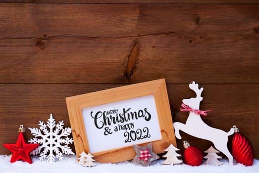 English Calligraphy Merry Christmas And Happy 2022. Red Christmas Ornament Like Tree, Ball And Wooden Deer. Wooden Background With Snow
