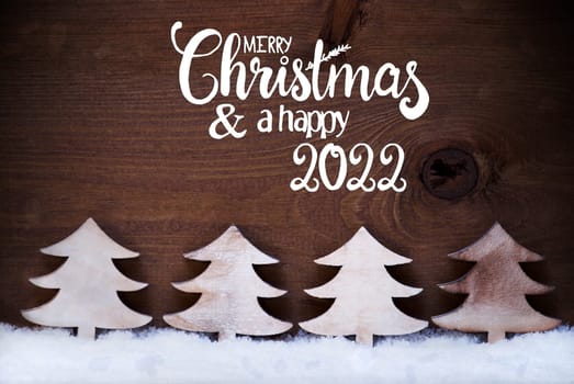 Egnlish Calligraphy Merry Christmas And Happy 2022. White Wooden Tree On Snow WIth Wooden Background