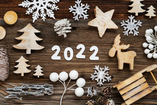 White Letters Building The Word 2020. Wooden Christmas Decoration Like Tree, Sled And Star. Brown Wooden Background