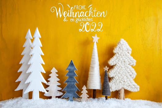 Christmas Trees With German Calligraphy Frohe Weihnachten Und Ein Glueckliches 2022 Means Merry Christmas And A Happy New Year. Yellow Wooden Background With Snow. Christmas Decoration With Stars.