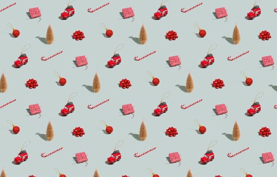 Gray green background pattern with Christmas, New Year symbol attribute objects and symbolic items concept. Small red taxi car toy, pink gift box present, lolli pop candy, lollypop, ball, fir tree