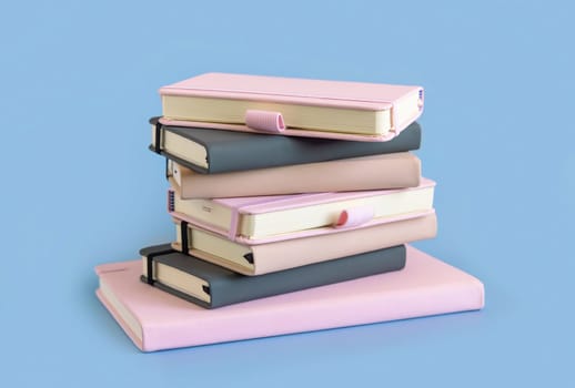 Stack of pink, beige and grey notebooks on light blue closeup. Textbook mockup. Educational, business and organizing concept
