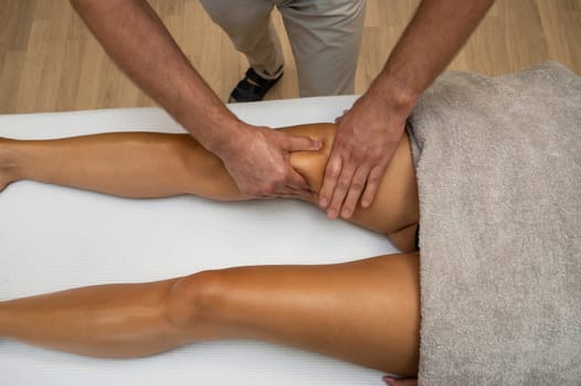 Woman getting legs lymphatic drainage massage in spa salon. Closeup. Body relaxation beauty and body care concept.