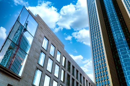 Modern architecture from skycraper in Frankfurt Hesse on a sunny day with crane in glass mirroring