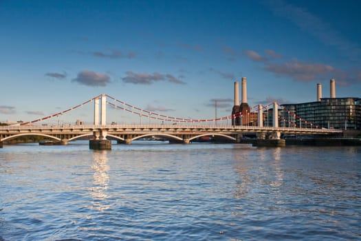 The River Thames with the Grosvenor Rail Bridge and Battersea Power Station in the background with blue sky and white clouds