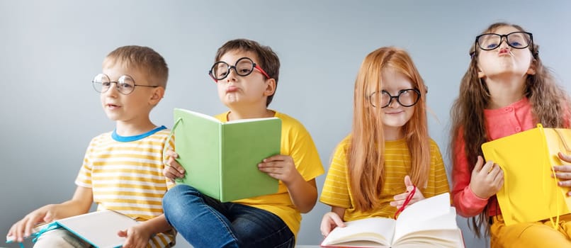 Group of children sitting indoors and reading books.. Concept of education and friendship.