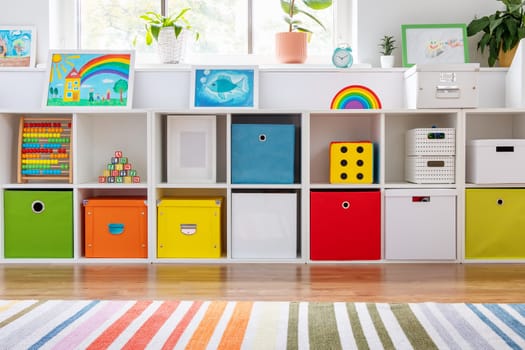 White nursery room with shelves and colourful boxes. Conceptual symbol of the preschool, kindergarten or child's cabinet.
