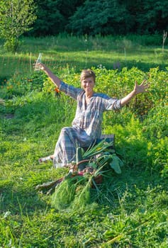 happy young woman with harvest in the garden