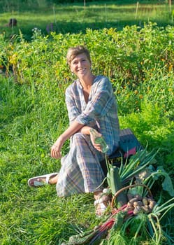 happy young woman with harvest in the garden
