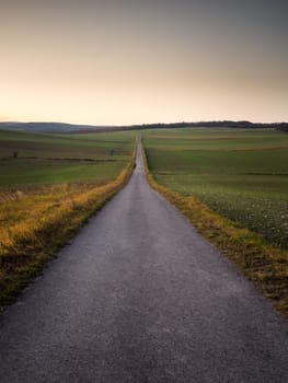 Lone road into the sunset sky