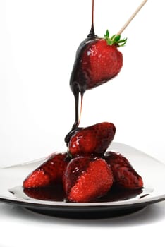 Pouring chocolate over fresh yummy strawberries