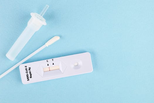 Negative result in rapid Ag Covid test on blue background. Copy space for text. Test kit.