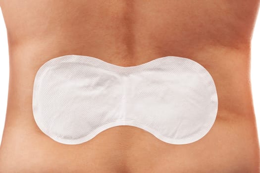 Medical heat patch on handsome man's back. Chronic back pain, burnout, overwork, extertion.