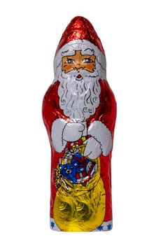 Chocolate Santa isolated. Close-up of a cheerful wrapped chocolate Father Christmas or the good Saint Nicholas figure isolated on a white background. Macro photography.