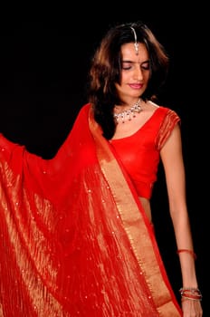 lovely and young Indian girl wearing traditional sari isolated over black