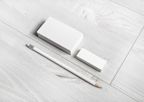 Blank business cards, pencil and eraser on wood background. Template for ID.