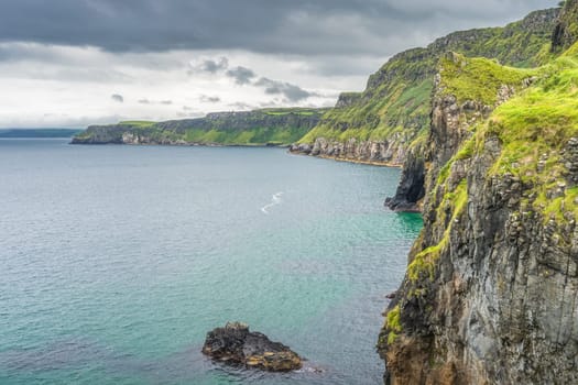 Coastline with tall limestone cliffs, Rathlin Island and turquoise Atlantic Ocean near Carrick a Rede rope bridge, Wild Atlantic Way, Northern Ireland