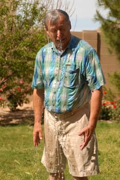 Senior man being splashed with a great deal of water