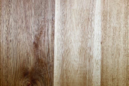 Background of brown and beige simulated wood grain vertical vinyl flooring planks closeup. Synthetic wood grain design planks brown and beige vertical vinyl flooring close-up of a flat background..