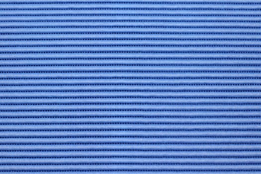 Repeating pattern of raised horizontal blue strips with small holes in between close-up background. .Medium blue background of synthetic ribbed raised lines with tiny holes in between bumps closeup.