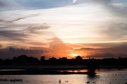 Giant dark cloud. Storm Clouds orange sky at Sunset nature landscape.