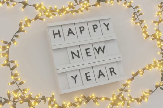 3d illustration. Happy New Year Text Light Box and Glowing light bulbs Christmas and New Year on white background . Copy Space For Message.