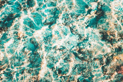 Vibrant blue white ripped water surface with clear transparent waves and nice sun sparkles over the reefs at Red sea or ocean. Conceptual abstract texture background. Travel or vacation summer concept