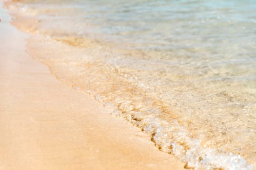 Close up aerial view of crystal clear turquoise sea and soft blue ocean waves, white foam on golden sandy tropical island summer beach, holidays border frame concept background, vacation backdrop