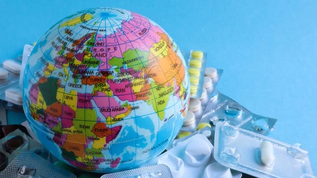 Ukraine, Kiev - April 14, 2020. The concept of a pandemic and global viral infection in America, Europe and around the world. Model of the globe and pills. A planet with packs of antiviral drugs
