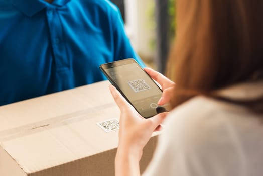 Asian customer young woman using mobile smartphone with QR code payment to receive parcel post box from delivery man, Hands of female scanning at door front house, Online shopping service concepts