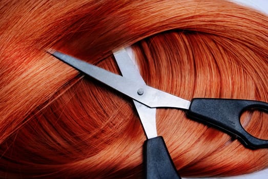 Long healthy red hair and professional scissors