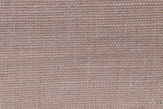 Beige fabric texture. Close-up of a brown seamless pattern for textile, bags or other garments. Macro.