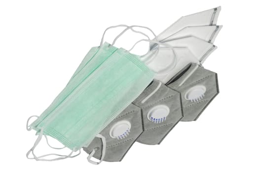 Closeup of gray and white N95 face masks or particle filtering half mask of the FFP3 protection class and green surgical masks or medical face mask isolated. Space.