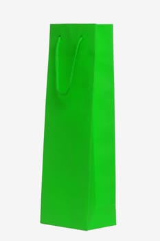 Closeup of a single green paper bag or pouch with green handle for shopping or for gifts isolated on a white background. Macro photograph.