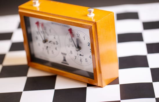 The  classic, mechanical chess clock on wooden chess board. Selective focus