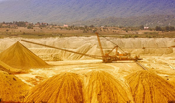 The own coal open pit landscape with enormous digging excavator