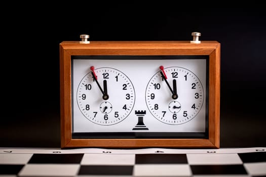 The  classic, mechanical chess clock on wooden chess board. Selective focus