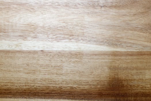 Flat background of slightly textured luxury vinyl flooring intended to look like wood planks. Luxury waterproof vinyl flooring with a rigged core that looks like wood grain in beige and brown close-up