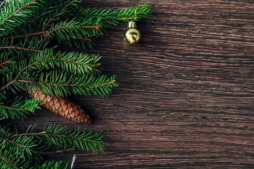 Decoration of Christmas Tree Green Branches on a Brown Background with CopySpace
