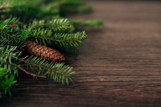 Decoration of Christmas Tree Green Branches on a Brown Background with CopySpace