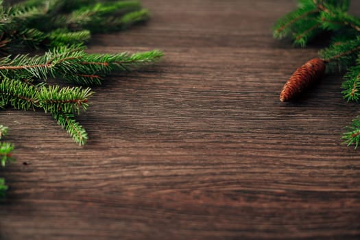 Decoration of Christmas Tree Green Branches on a Brown Background with Copy Space