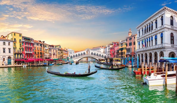 Venice Grand Canal, view of the Rialto Bridge and gondoliers, Italy.