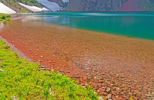 Red Rocks in A Blue Lake in Lake Okatomi in Glacier National Park in Montana